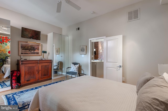 bedroom with light wood-type flooring, ensuite bath, and ceiling fan