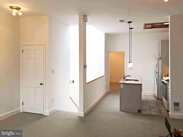 interior space with hanging light fixtures, sink, white appliances, a kitchen island, and carpet floors