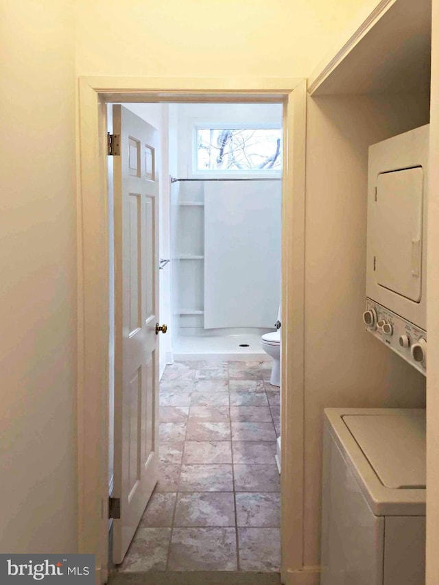 interior space featuring stacked washer and clothes dryer