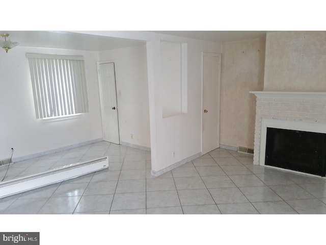 unfurnished living room with light tile patterned floors, a baseboard heating unit, and a brick fireplace