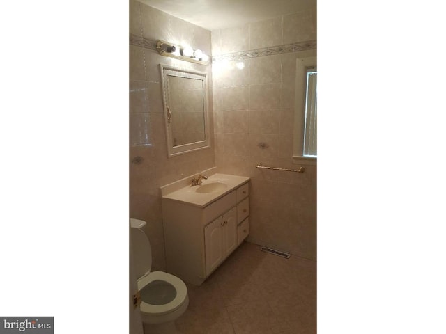 bathroom with vanity, tile walls, toilet, and tile patterned floors