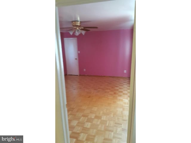 empty room featuring ceiling fan and light parquet floors