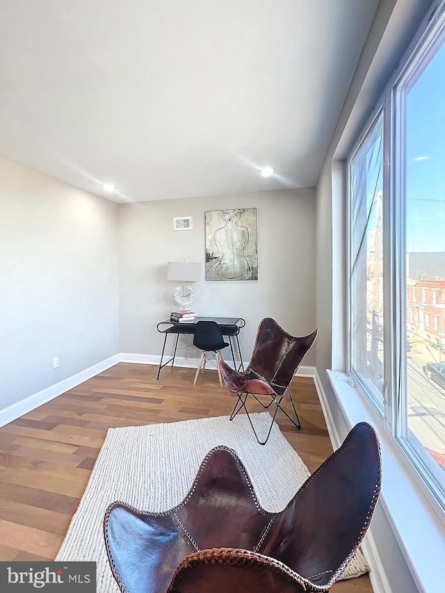 living area with hardwood / wood-style flooring and a wealth of natural light