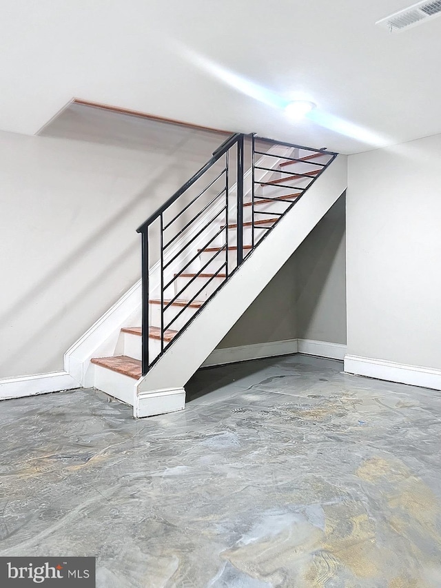 stairway featuring concrete flooring