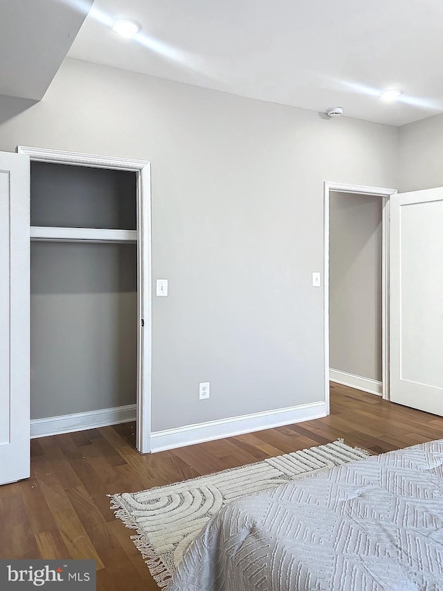 unfurnished bedroom featuring a closet and hardwood / wood-style floors