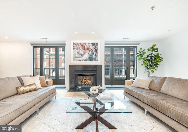 living area with a fireplace with flush hearth, visible vents, and recessed lighting