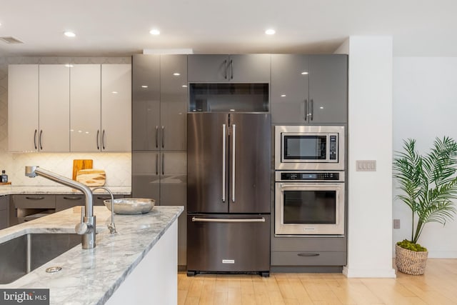 kitchen featuring stainless steel appliances, gray cabinetry, and modern cabinets