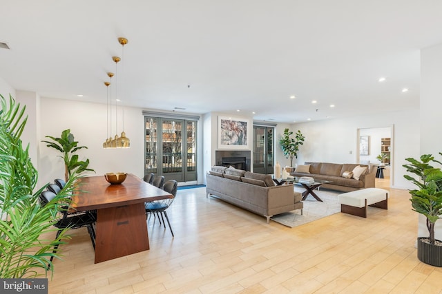 living room with light wood-type flooring, a fireplace, visible vents, and recessed lighting