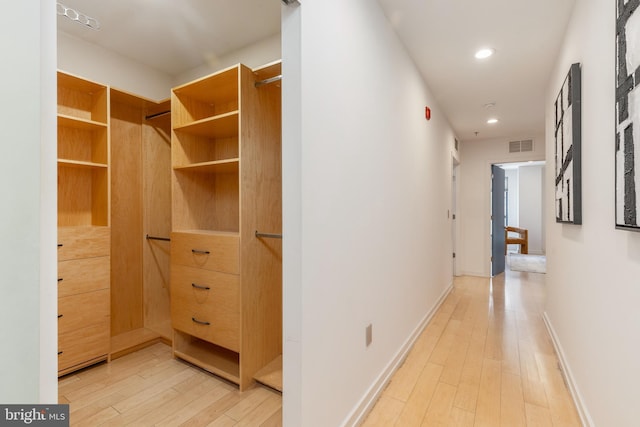 hallway with recessed lighting, visible vents, light wood-style flooring, and baseboards