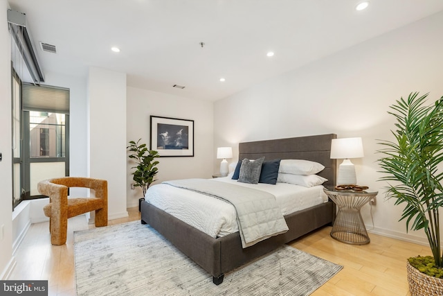 bedroom featuring light wood-style floors, recessed lighting, visible vents, and baseboards