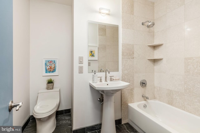 bathroom with a sink, bathtub / shower combination, toilet, and baseboards