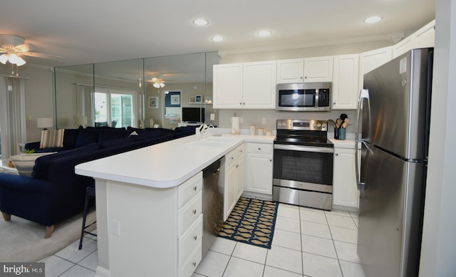 kitchen with white cabinets, kitchen peninsula, appliances with stainless steel finishes, and sink