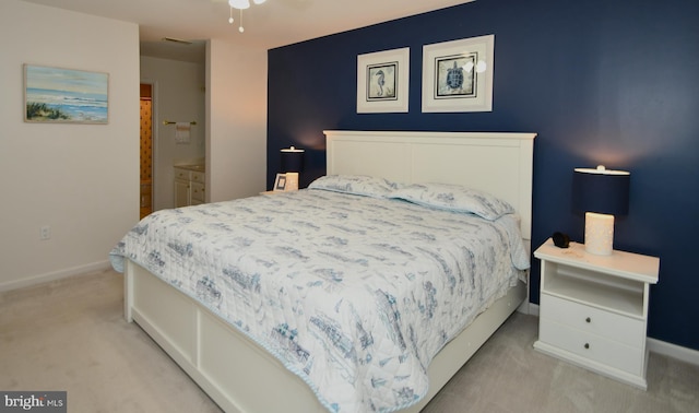 bedroom featuring light carpet and ensuite bathroom