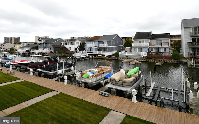 view of dock with a lawn and a water view