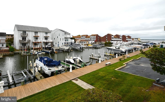 view of dock with a water view and a yard