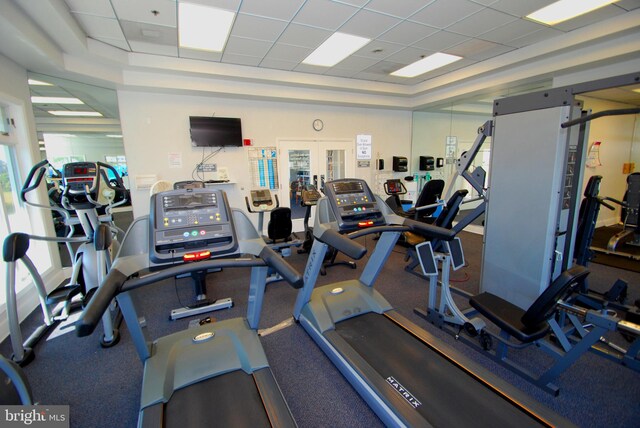 exercise room featuring a raised ceiling and a drop ceiling