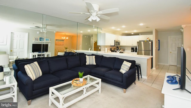 tiled living room with ceiling fan with notable chandelier