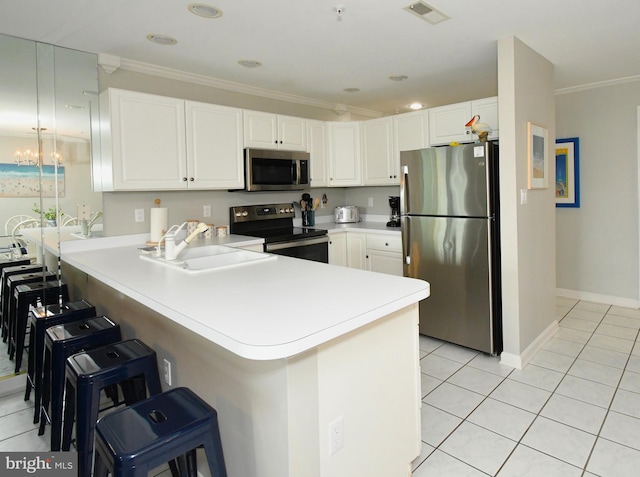 kitchen featuring kitchen peninsula, a breakfast bar area, stainless steel appliances, ornamental molding, and sink