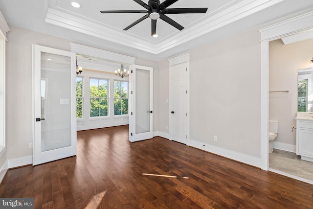 unfurnished room with a raised ceiling, ceiling fan with notable chandelier, and dark hardwood / wood-style floors