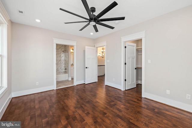 unfurnished bedroom featuring ceiling fan, ensuite bathroom, and dark wood-type flooring