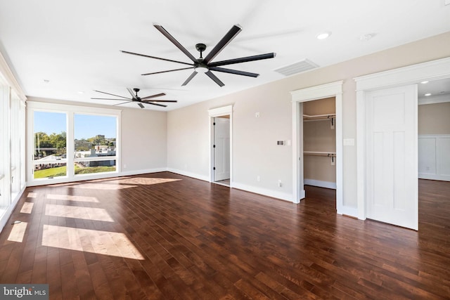 unfurnished living room featuring ceiling fan and dark wood-type flooring