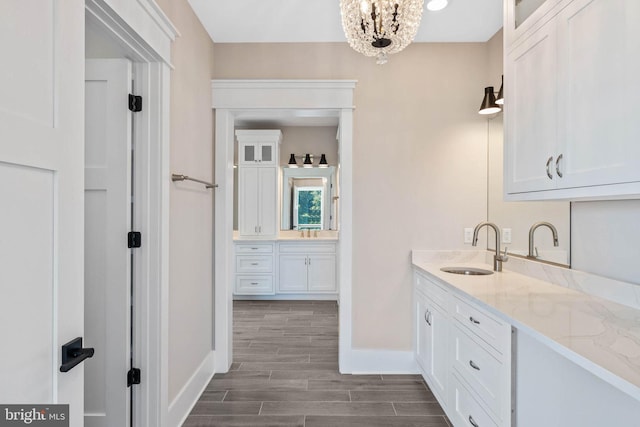 bathroom with an inviting chandelier, hardwood / wood-style flooring, and vanity