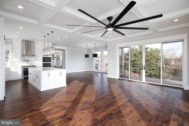 kitchen with stainless steel appliances, dark hardwood / wood-style flooring, wall chimney range hood, and a center island