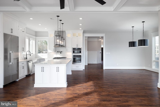 kitchen with stainless steel appliances, white cabinetry, a kitchen island, and dark hardwood / wood-style flooring