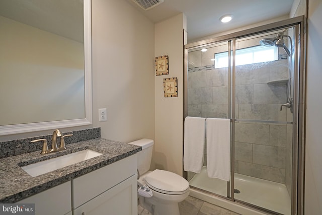 bathroom with vanity, tile patterned flooring, toilet, and a shower with door