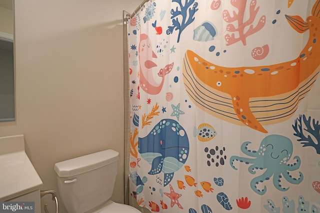 bathroom featuring walk in shower, vanity, and toilet