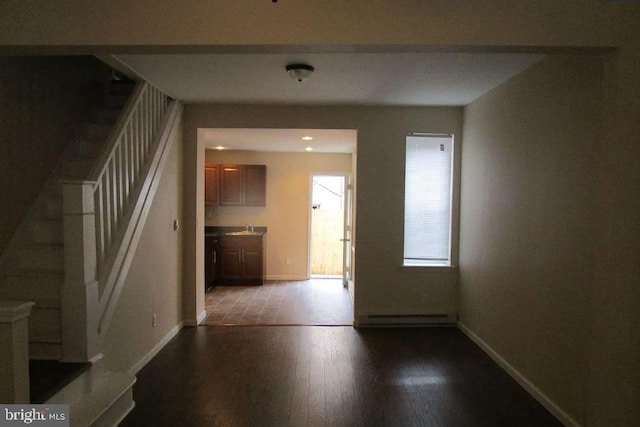 interior space with sink, a baseboard radiator, and hardwood / wood-style floors