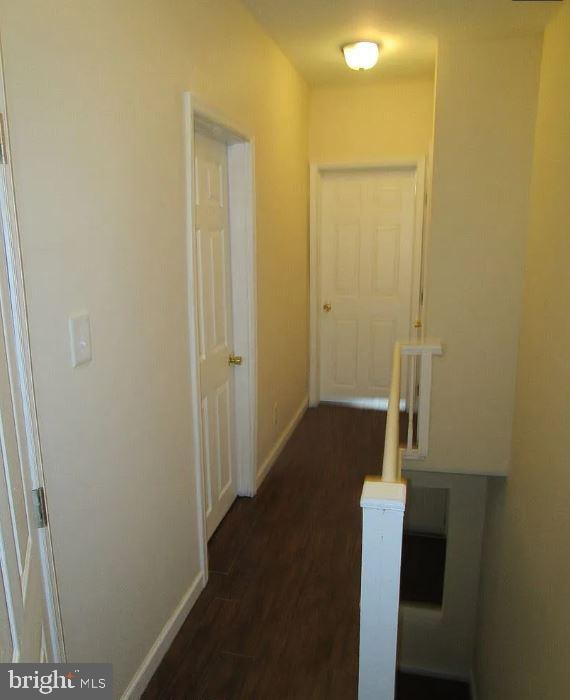 corridor with dark hardwood / wood-style flooring