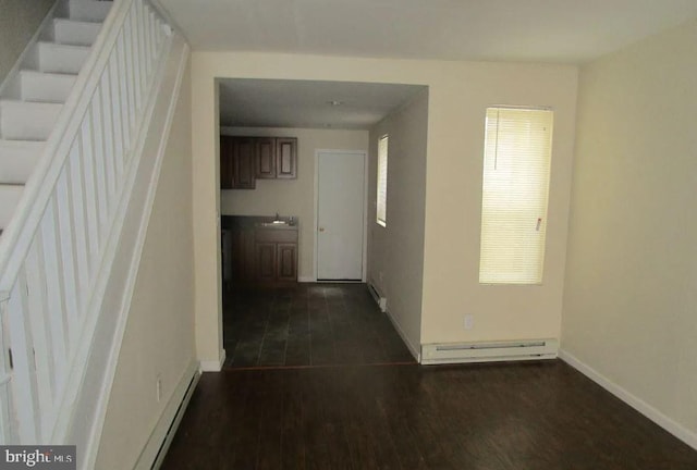 hallway with dark hardwood / wood-style floors, a baseboard heating unit, and sink