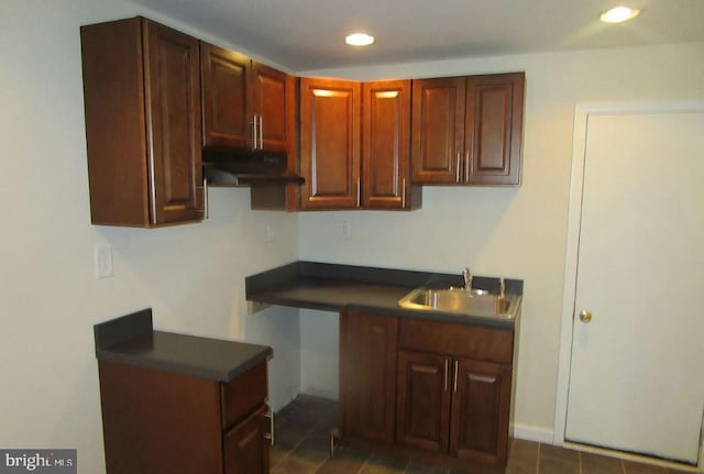 kitchen featuring dark tile patterned flooring and sink