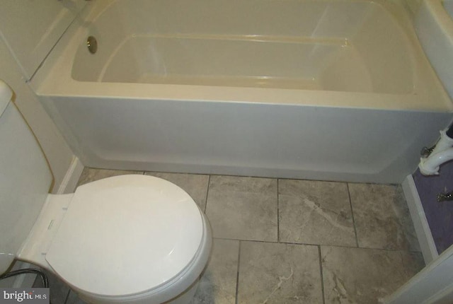 bathroom featuring a tub, toilet, and tile patterned floors