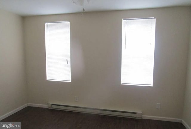 unfurnished room featuring a baseboard radiator and dark hardwood / wood-style flooring