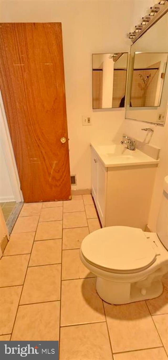 bathroom with vanity, toilet, and tile patterned floors