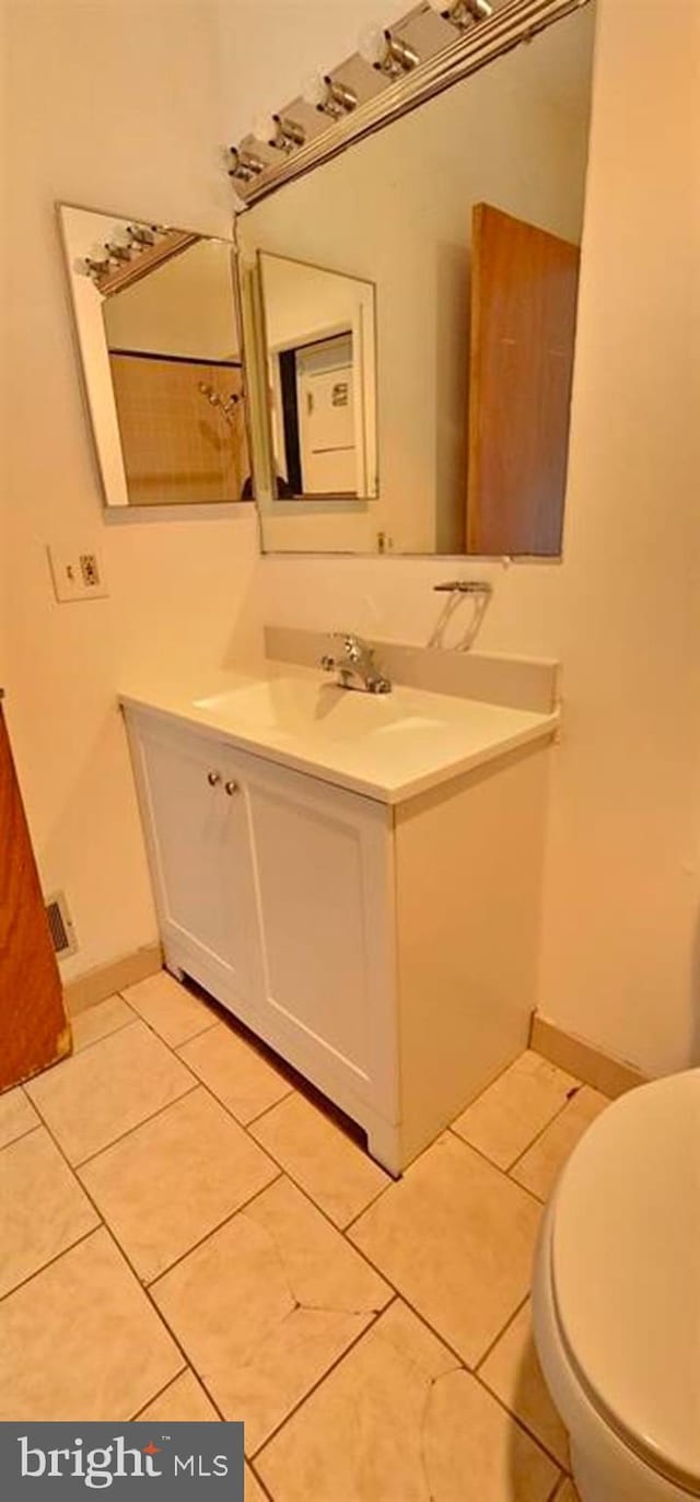 bathroom with vanity, tile patterned flooring, and toilet