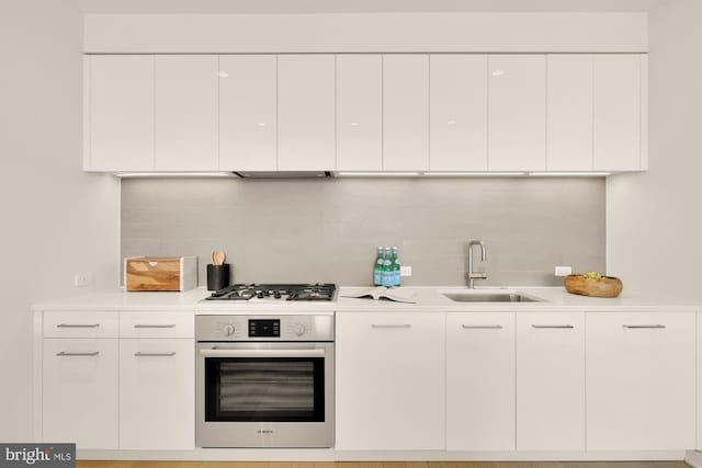 kitchen with white cabinets, appliances with stainless steel finishes, backsplash, and sink