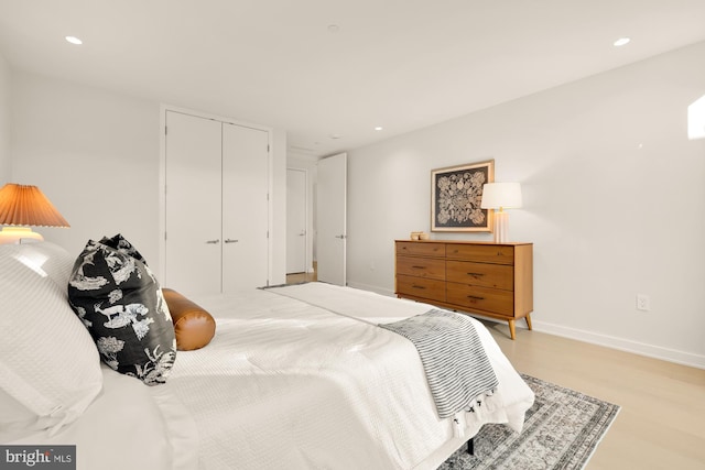 bedroom with light hardwood / wood-style flooring and a closet