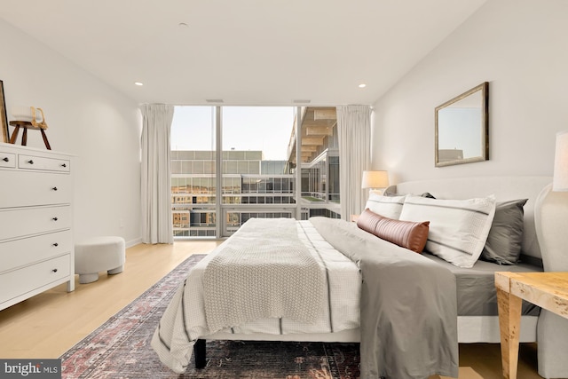 bedroom featuring floor to ceiling windows and light hardwood / wood-style floors