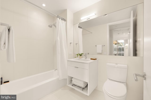 full bathroom featuring vanity, tile patterned floors, shower / bath combination with curtain, toilet, and tile walls