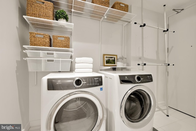 washroom with light tile patterned floors and washing machine and dryer