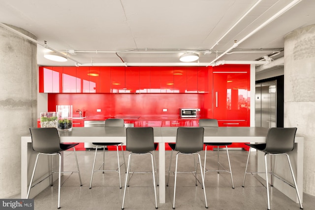 kitchen with elevator, sink, and appliances with stainless steel finishes