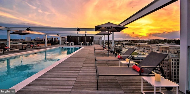 pool at dusk featuring a patio area