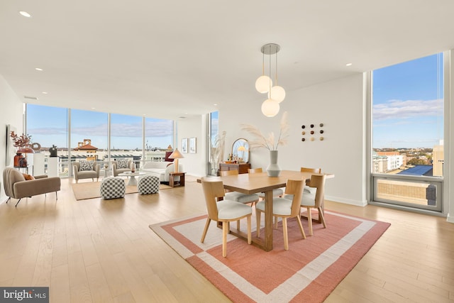 dining area with plenty of natural light, expansive windows, and light wood-type flooring