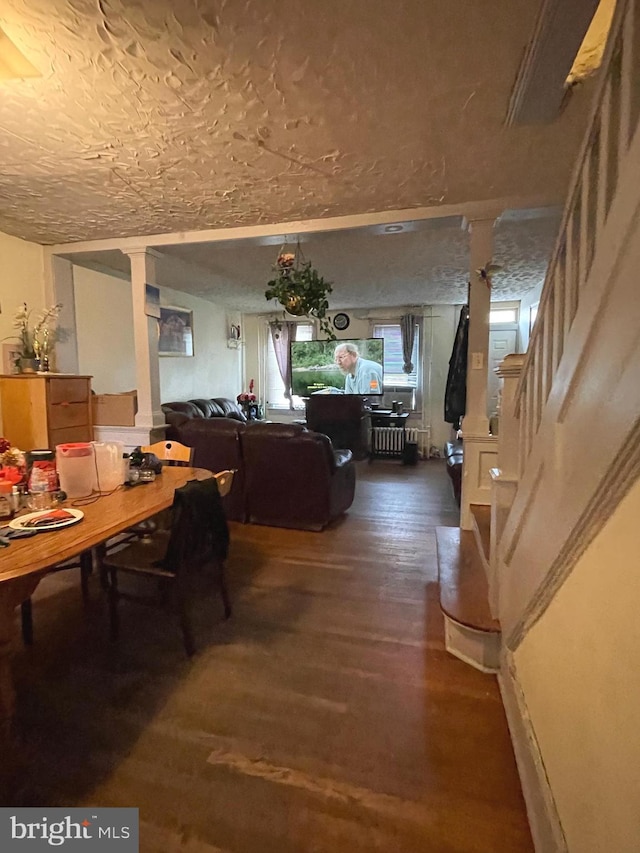 dining area with a textured ceiling and dark wood-type flooring