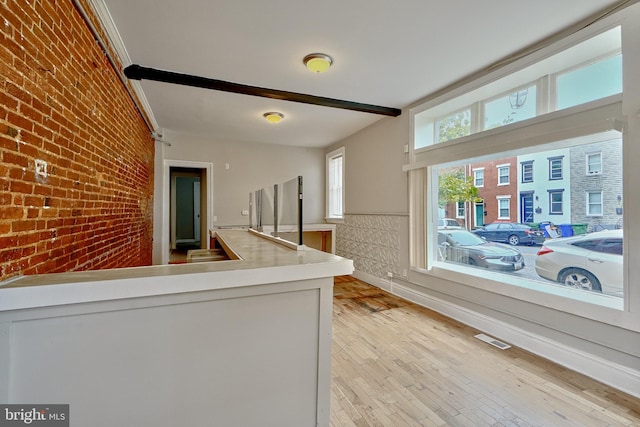 kitchen with light hardwood / wood-style floors and brick wall