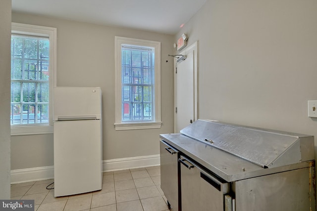 kitchen with white refrigerator and light tile patterned flooring