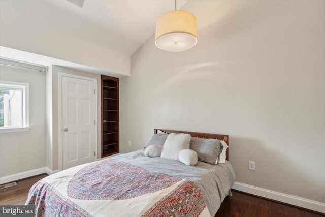 bedroom featuring lofted ceiling and dark hardwood / wood-style flooring